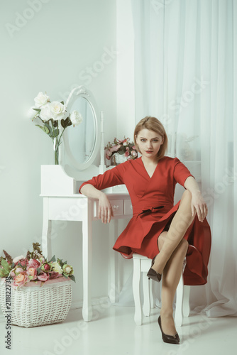 Woman in red dress. sexy woman grooming in morning at mirror. bedroom decor for elegant woman. confident and beautiful. Be A Woman A Man Needs.