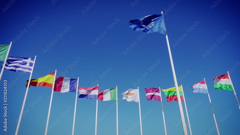 Flags of European Union and european countries against the blue sky. Smooth slowmotion from a 120 fps original shoot