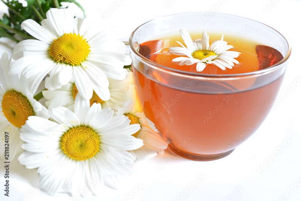 bouquet of field chamomile and glass transparent cup of brown warm tea bouquet of field chamomile and glass transparent cup of brown warm tea