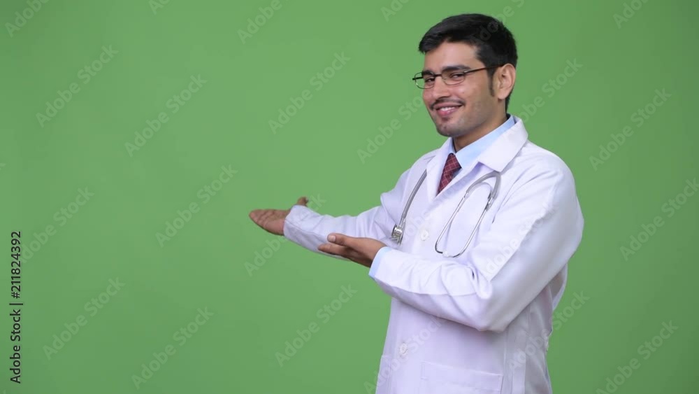 Young handsome Persian man doctor showing something Young handsome Persian man doctor showing something