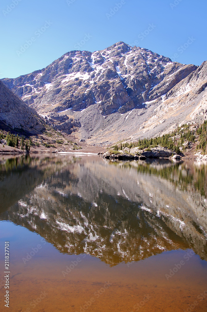 Blue sky and soaring mountain peaks reflected in the pristine waters of South crestone lake in the Sangre De Cristo Mnts of Southern Colorado.