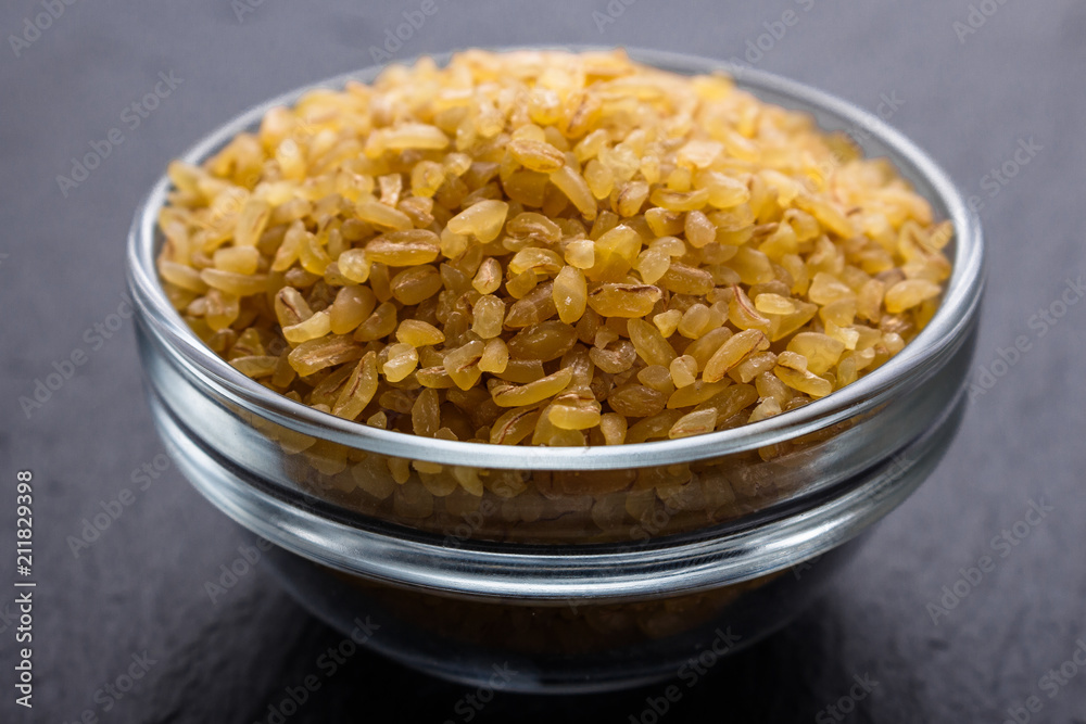 raw bulgur on a dark stone background raw bulgur on a dark stone background