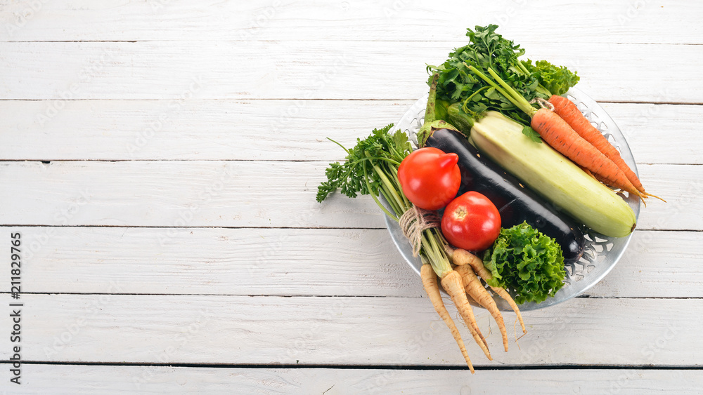 Fresh vegetables in a plate. Organic food. On a wooden background. Top view. Copy space. Fresh vegetables in a plate. Organic food. On a wooden background. Top view. Copy space.