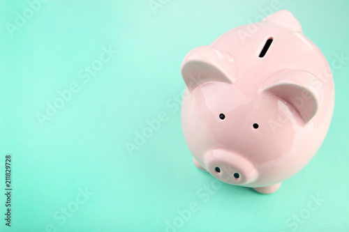 Pink piggy bank on mint background