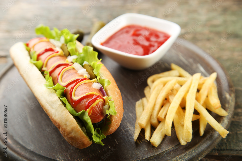Hot dog with vegetables and french fries on wooden table Hot dog with vegetables and french fries on wooden table