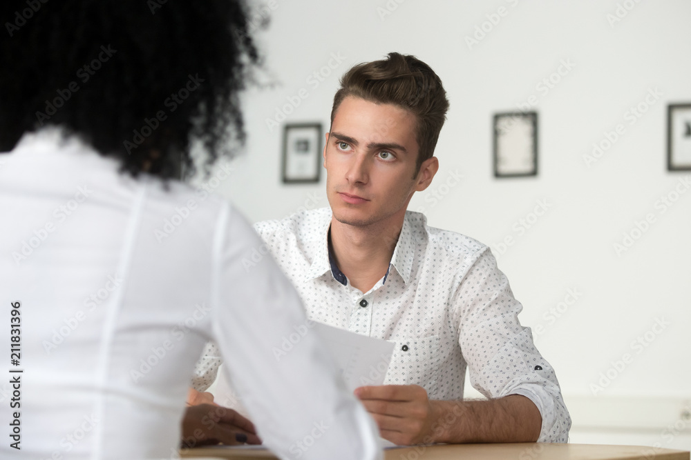 Serious millennial worker listen to female colleague arguments and ideas on project implementation, focused employee analyze coworker thoughts, people brainstorming, developing strategies at briefing