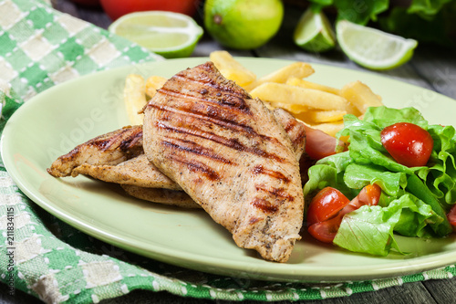 Grilled chicken breasts served with fries