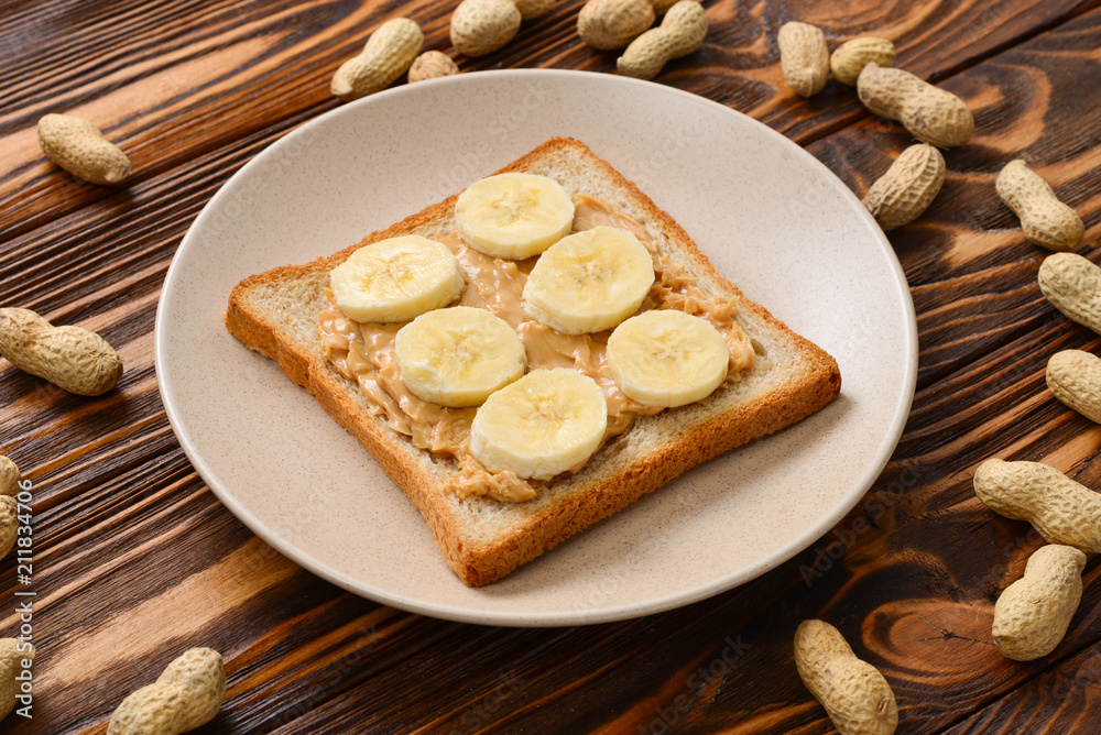 Peanut butter toast with banana slices on wooden background Peanut butter toast with banana slices on wooden background