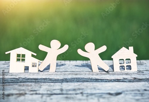 little wooden men in houses. Symbol of neighborhood, friendship, teamwork and sweet home concept photo