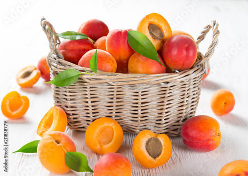 Fresh apricots on a white wooden background.