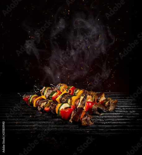 Chicken skewers on the grill with flames