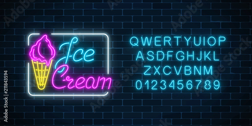 Glowing neon ice cream cafe signboard with alphabet on dark brick wall background. Fruit ice-cream in waffle cone.