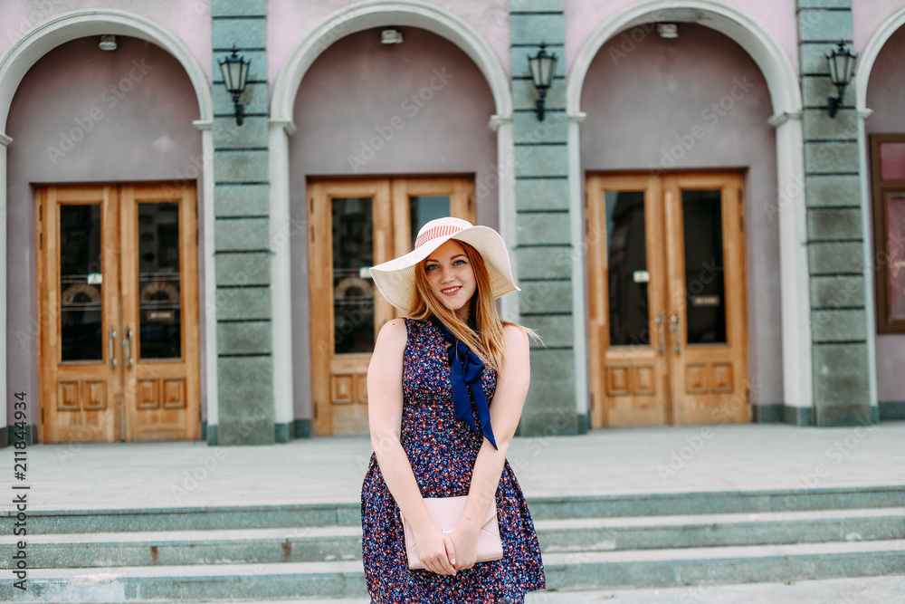 girl shy on city street hat handbag
