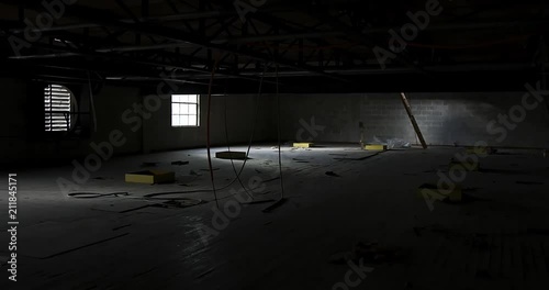 Wobbly and Eerie wide shot of abandoned warehouse attic with window light