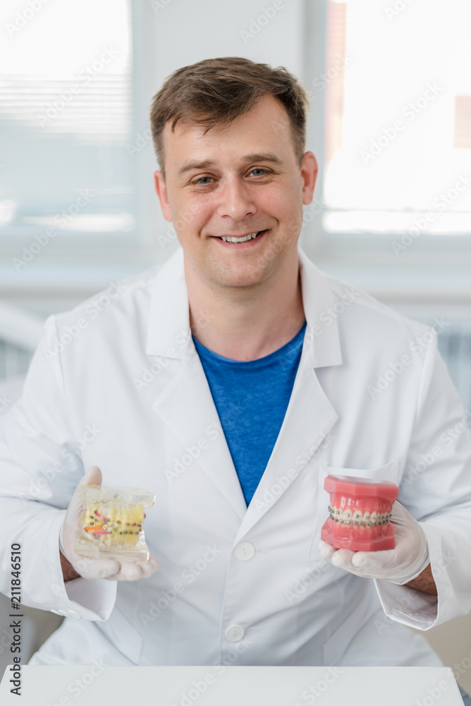 doctor orthodontist shows how the system of braces on teeth is arranged doctor orthodontist shows how the system of braces on teeth is arranged