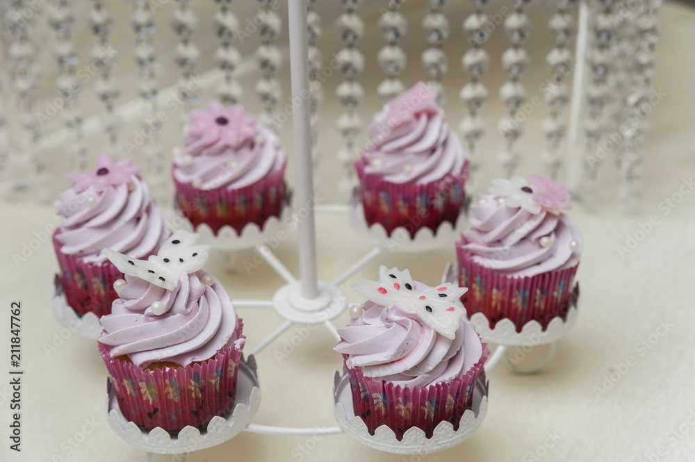 Pink cupcakes/Wedding candy bar featuring pink frosting on cupcakes arranged in a special support.