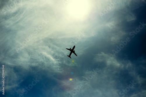Fototapeta Naklejka Na Ścianę i Meble -  A silhouette of a plane flying overhead on a clear day.