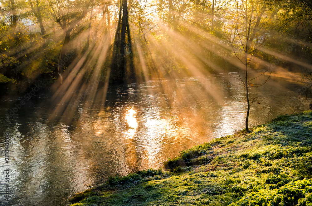 Fototapeta premium Herbststimmung an einem Fluß mit Sonnenstrahlen