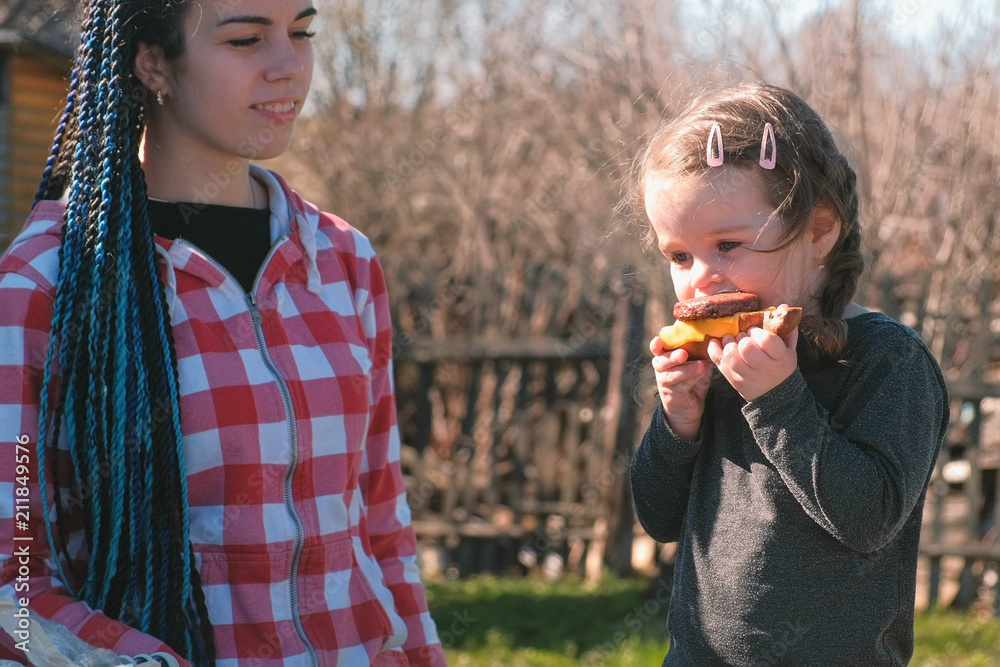 Fototapeta premium Mom feed sandwich her little daughter.