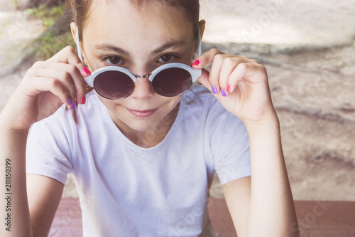 Happy little girl with sunglasses sitting