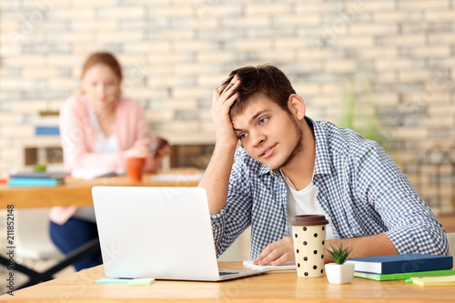 Teenager with laptop studyi...