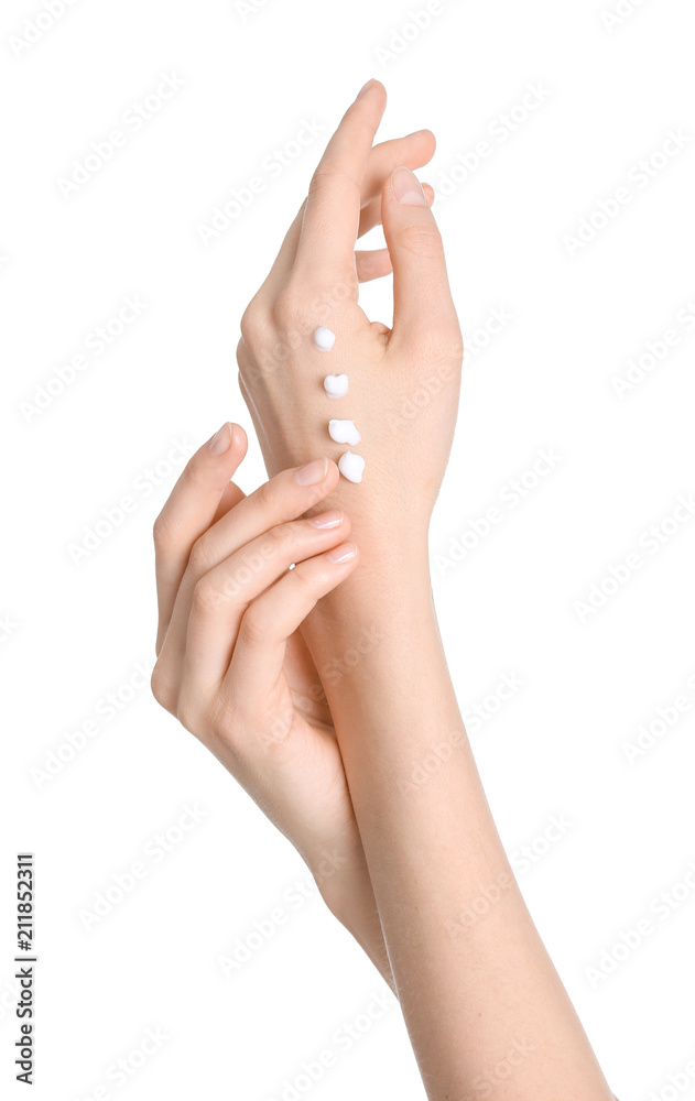 Young woman applying hand cream on white background