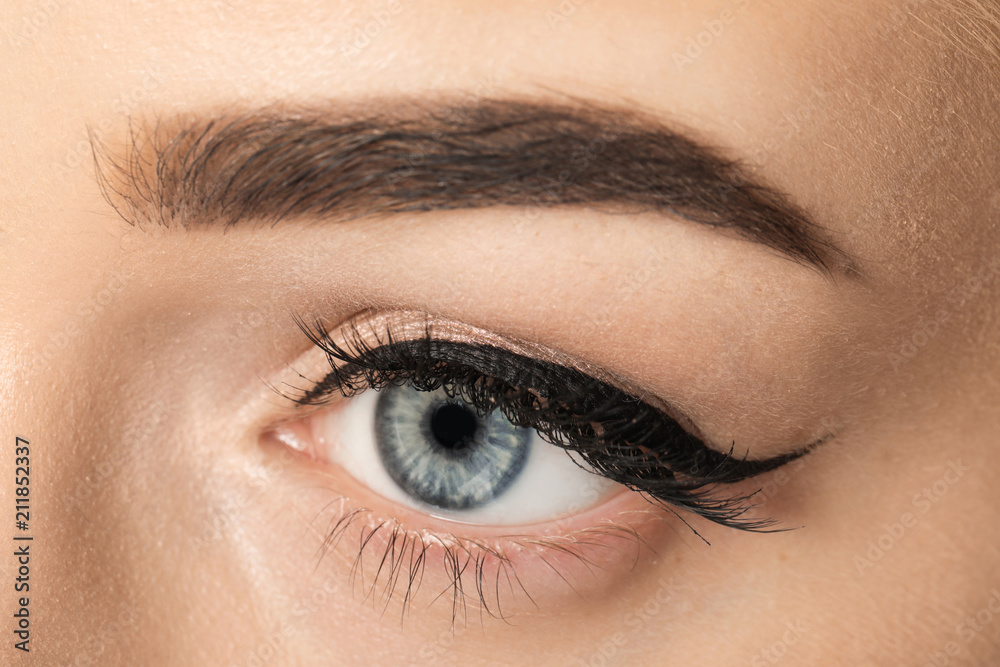 Fototapeta premium Eye of young woman with beautiful eyebrow after correction, closeup