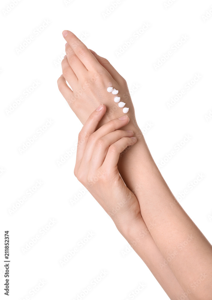 Young woman applying cream onto her hands on white background, closeup