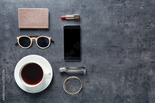 Flat lay composition with cup of coffee, smartphone and stylish accessories on grey background. Blogger concept