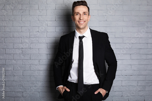 Male real estate agent on brick wall background