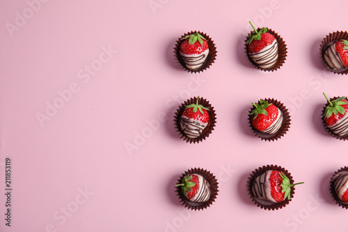 Flat lay composition with chocolate covered strawberries on color background