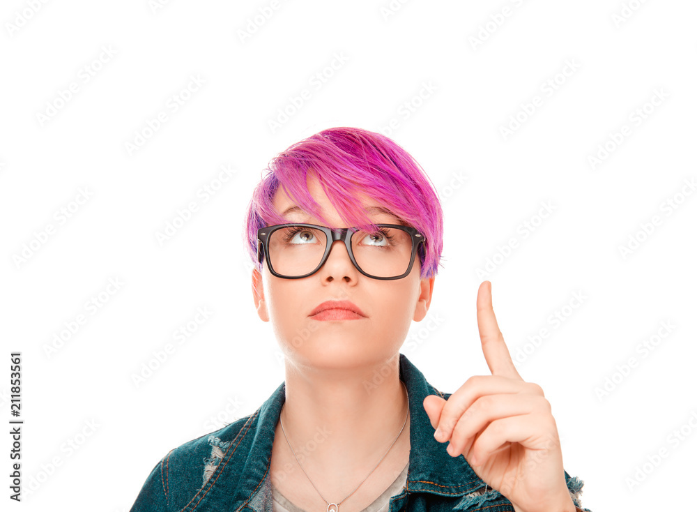 Look up here. Beautiful funny confused woman presenting showing copy space above head with index finger hand isolated light gray white background. Beauty hair up black shirt full makeup natural lips