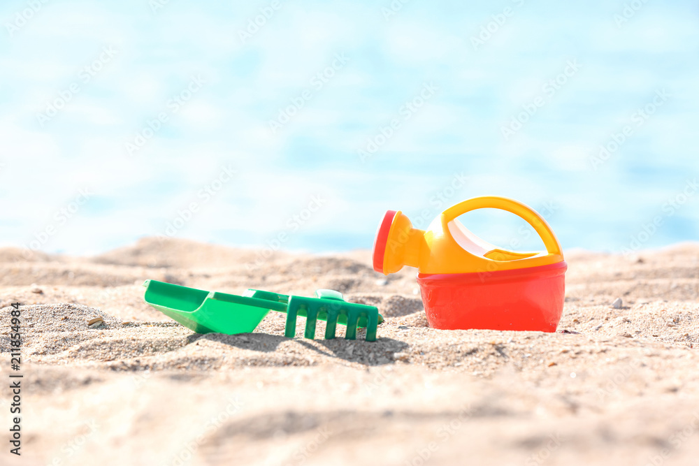 Children toys on sand near sea. Beach object