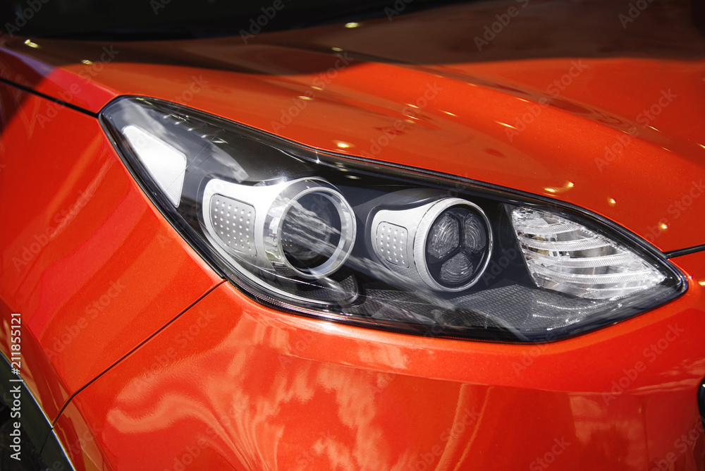 Left headlight of the new clean red sports car Left headlight of the new clean red sports car