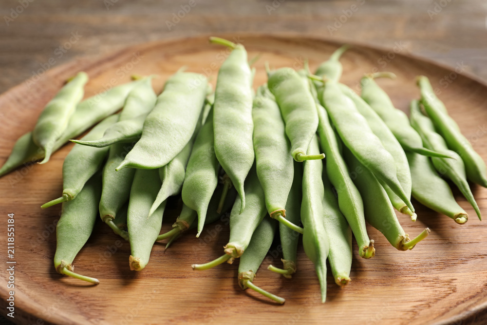 Wooden plate with fresh green beans, closeup Wooden plate with fresh green beans, closeup