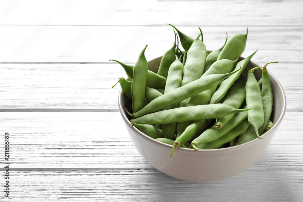 Bowl with fresh green beans on wooden table Bowl with fresh green beans on wooden table