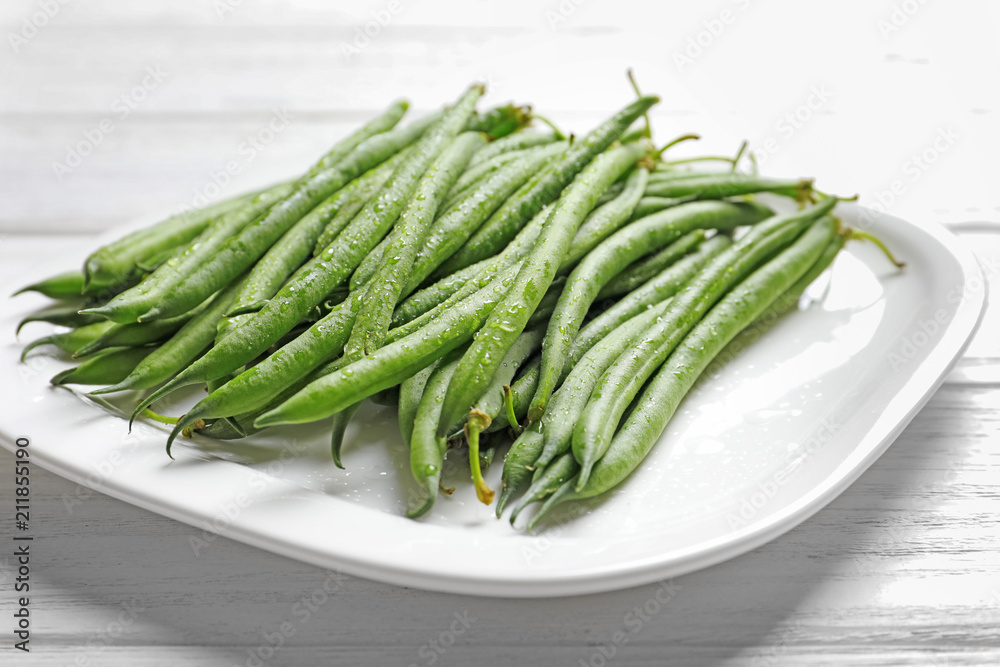 Plate with fresh green French beans on table, closeup Plate with fresh green French beans on table, closeup