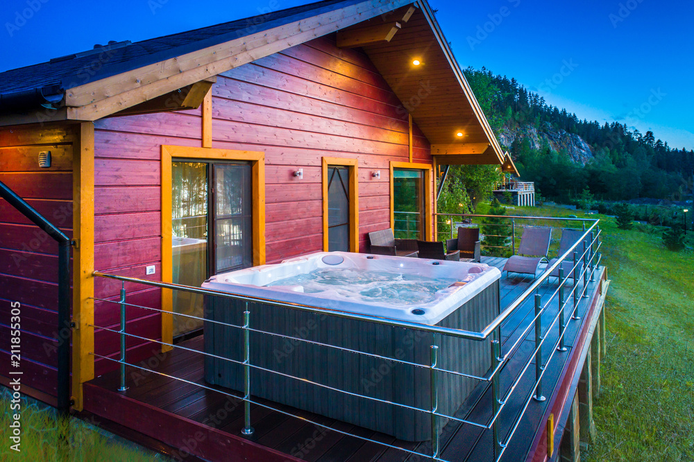 Cottage with Jacuzzi. Hot tub on the balcony of the house. Vacation home.  Cottage with balcony. foto de Stock | Adobe Stock