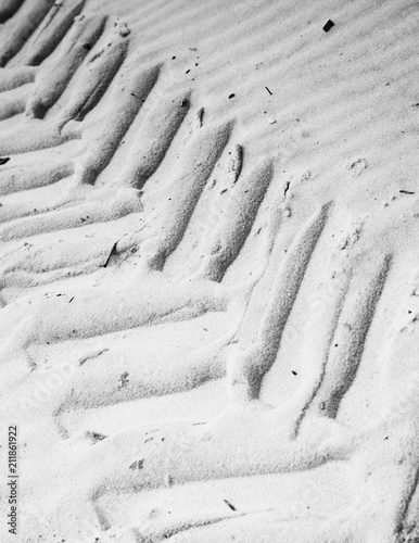 The black and white imprint of a tire tread in the sand on the beach at Waveland, Mississippi photo