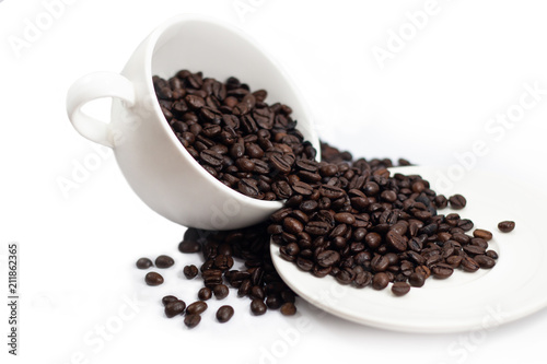 beverage concept of coffee beans heap with white cup and saucer . black and brown color seeds isolated white background . 