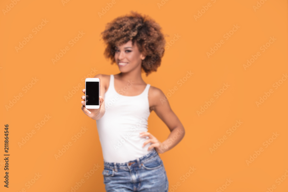 Smiling afro girl showing blank screen mobile phone. Smiling afro girl showing blank screen mobile phone.