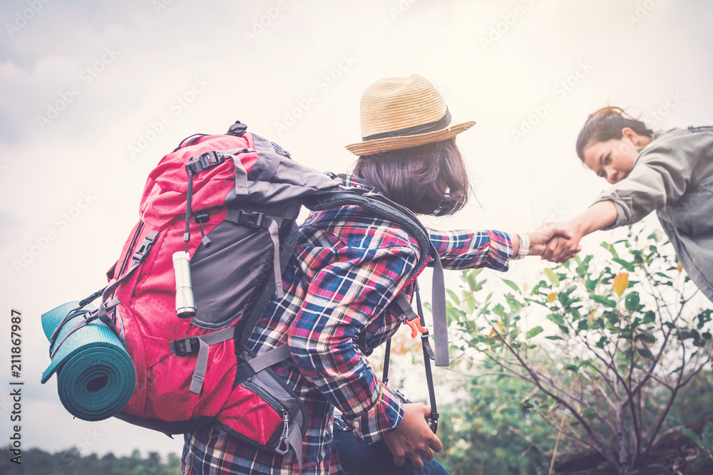 Women helping partner backpacker on holiday travel concept,selective and soft focus,tone of hipster style Women helping partner backpacker on holiday travel concept,selective and soft focus,tone of hipster style