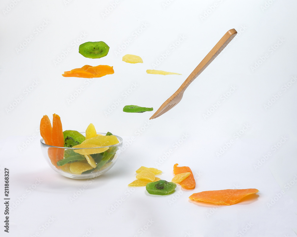 Dry preserved green kiwi pineapple ripe fruit slice colorful sweet on black marble slate background glass bowl flying floating elevated drooping Dry preserved green kiwi pineapple ripe fruit slice colorful sweet on black marble slate background glass bowl flying floating elevated drooping