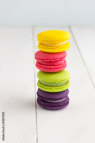 Colorful Macaroons on white wooden background.