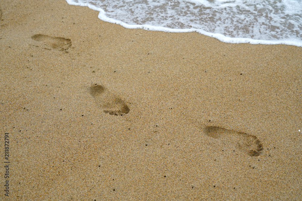 footprints on the beach sand with sea wave footprints on the beach sand with sea wave