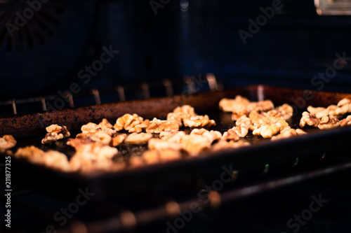 Walnuts roasting in the oven on a cooking pan