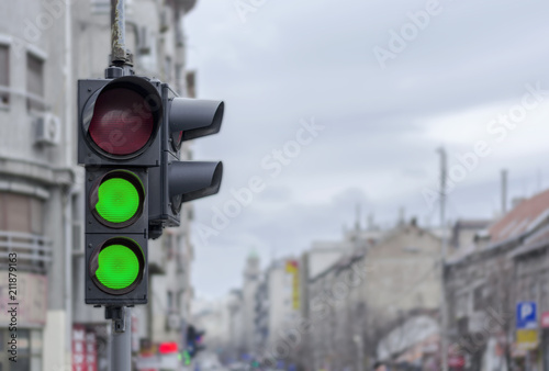 Two green semaphore light in Ccity urban blury background