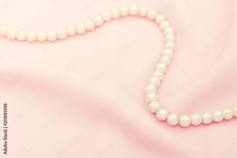 Pearl necklace on the pink fabric with copy space.
