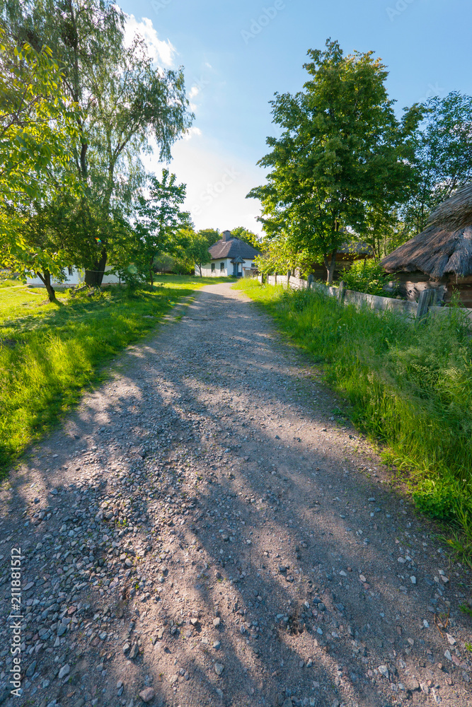 a path on the street of old rural houses with reed roofs. architectural memo a path on the street of old rural houses with reed roofs. architectural memo