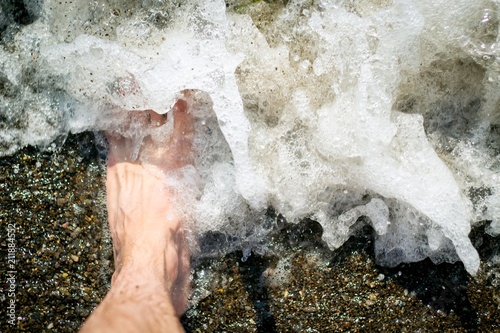 man s foot in sea water